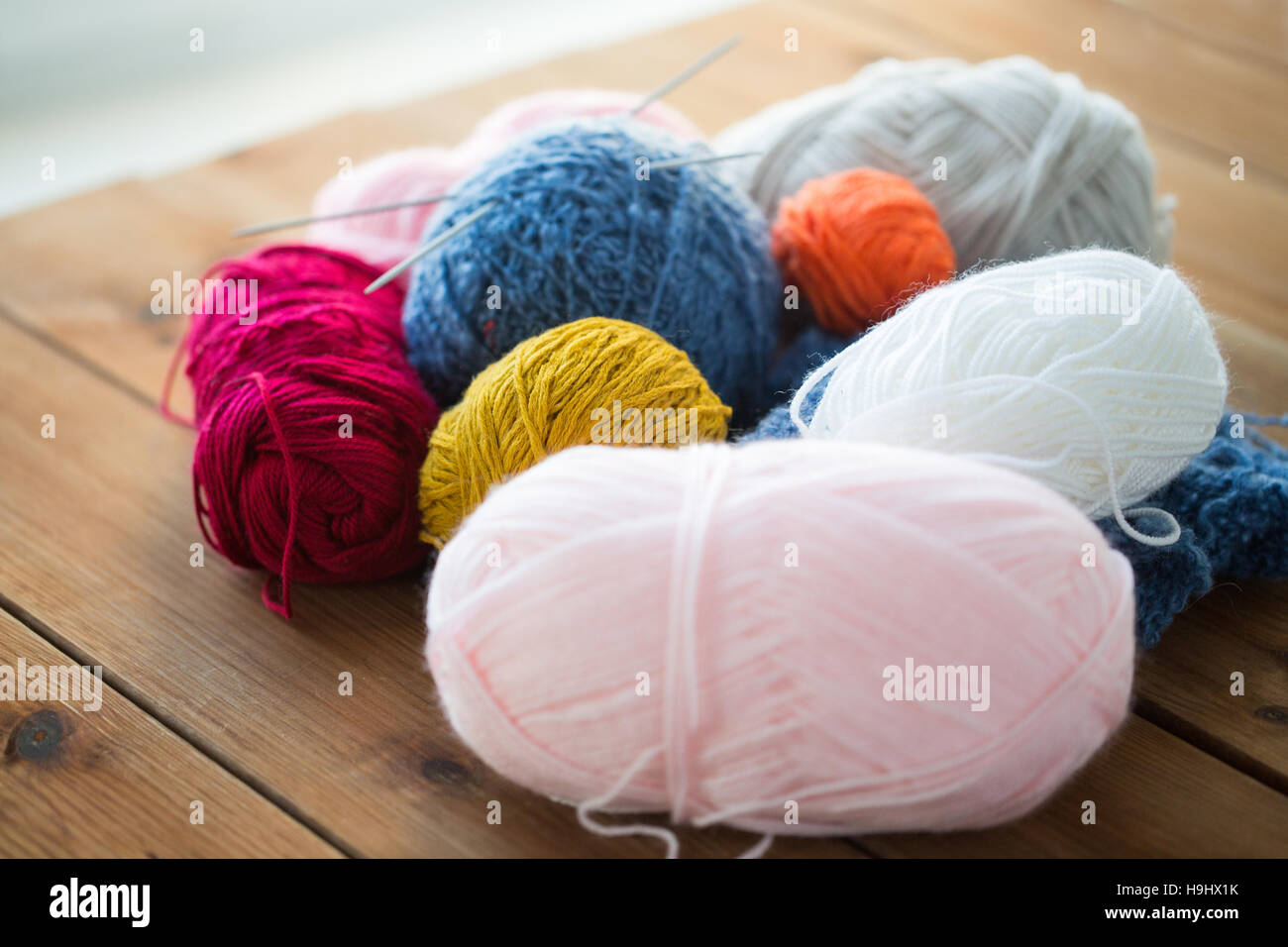 knitting needles and balls of yarn on wood Stock Photo - Alamy