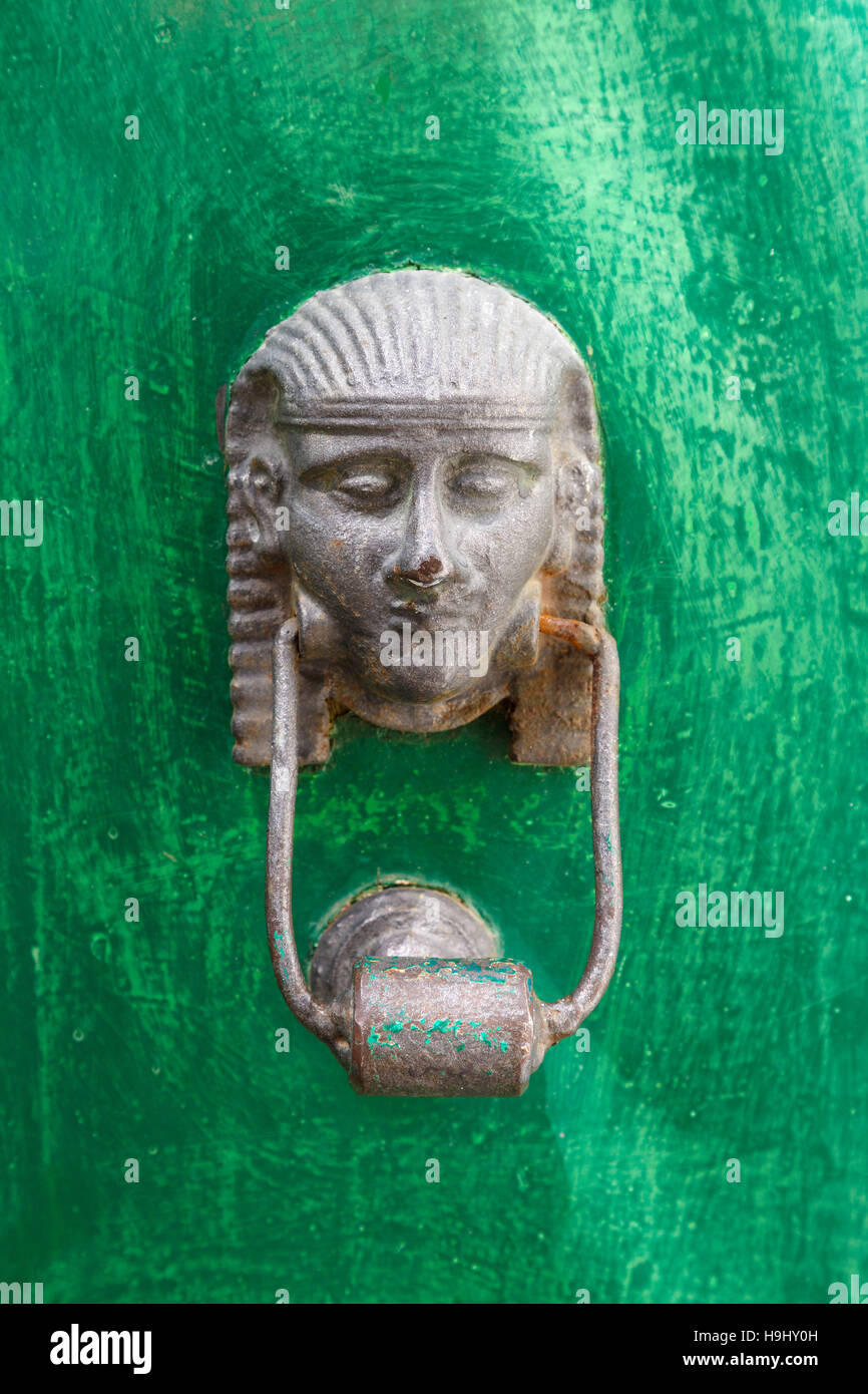 Egyptian styled knocker on a green painted door. Stock Photo