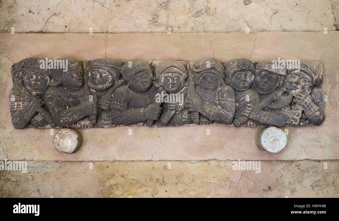 A wall sculpture of medieval fighters with weapons at the 11thC Villa Cimbrone, Ravello, Southern Italy. Stock Photo
