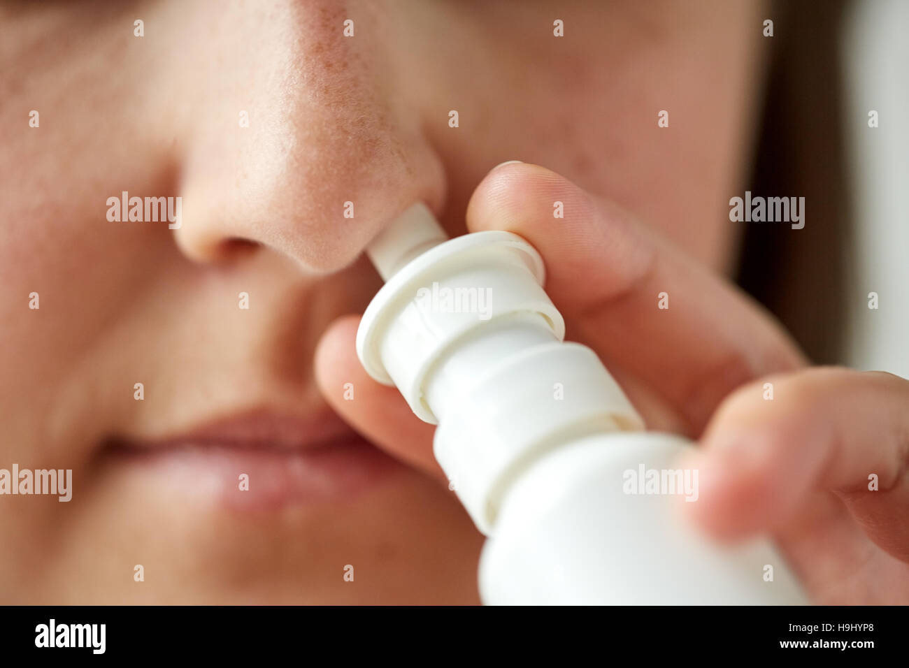 close up of sick woman using nasal spray Stock Photo