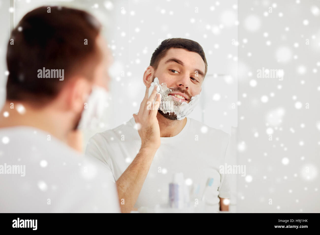 happy man applying shaving foam at bathroom mirror Stock Photo Alamy