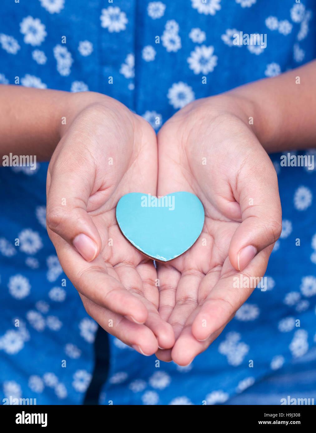 Girl holding wood shape of heart . Concept for giving love. Stock Photo