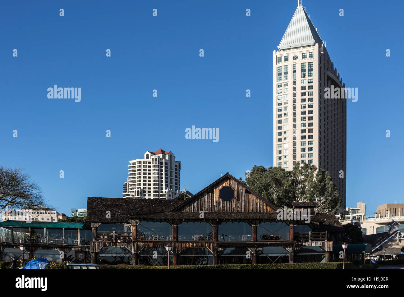 historic harbor house restaurant on san diego bay with hotels in distance Stock Photo