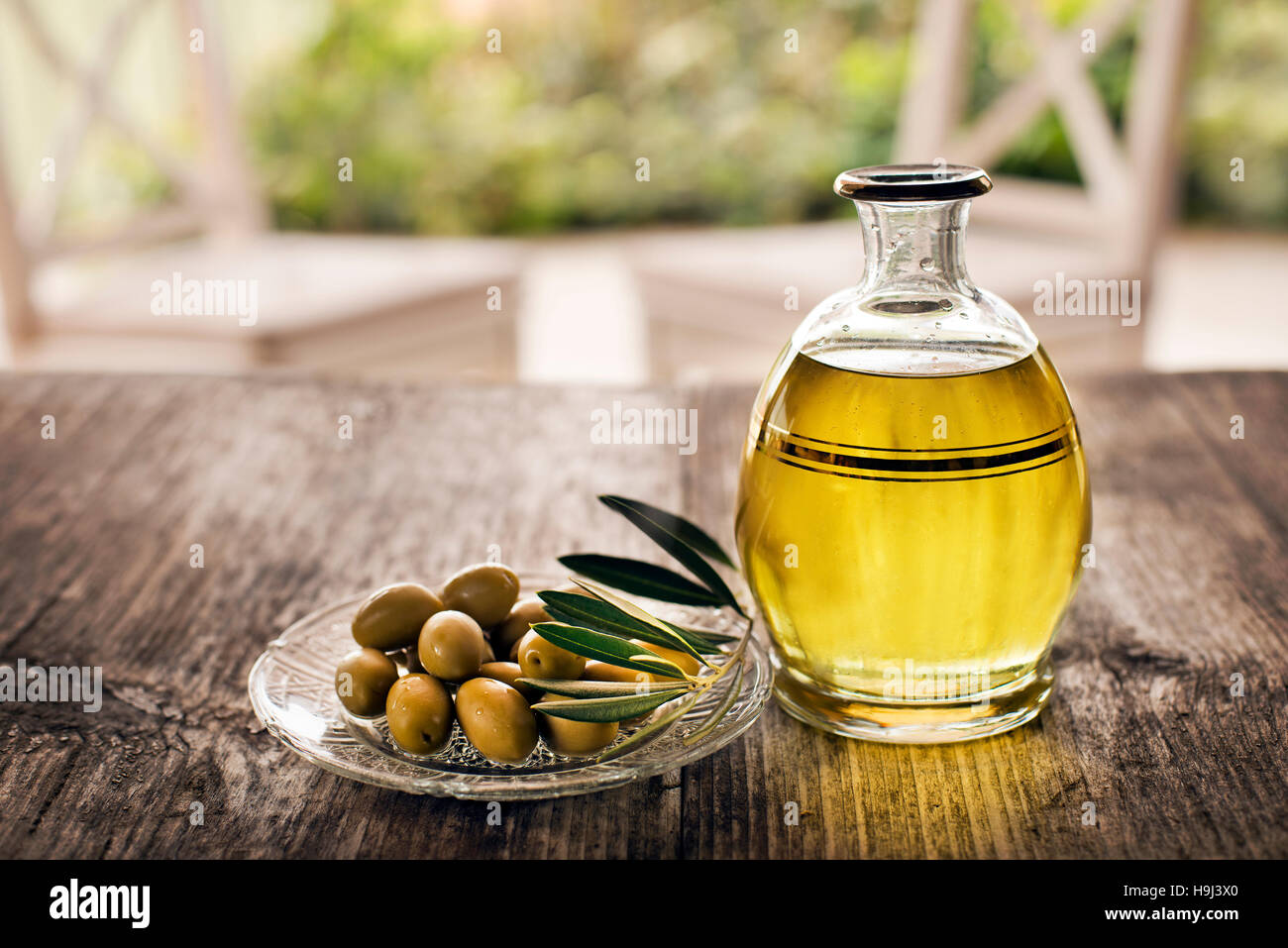 Olive oil and olive branch on the wooden table Stock Photo - Alamy