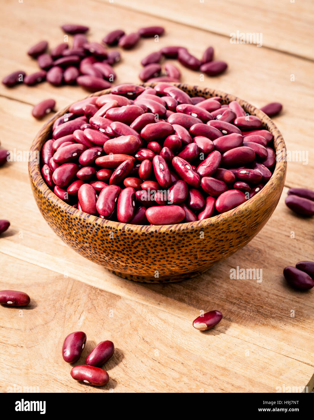 Close up red kidney beans in wooden bowl on wooden background. S Stock Photo
