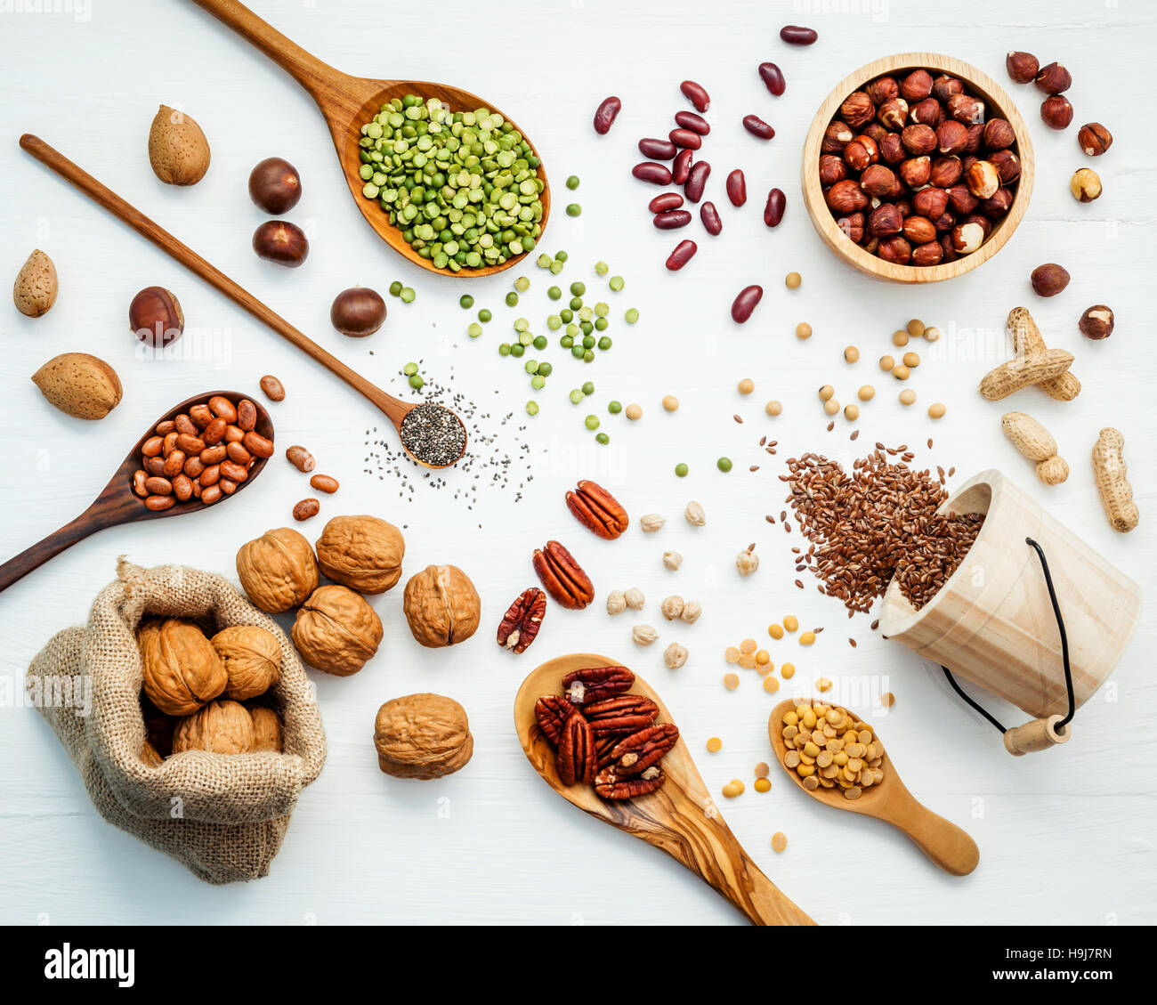 Bowls and spoons of various legumes and different kinds of nuts Stock Photo