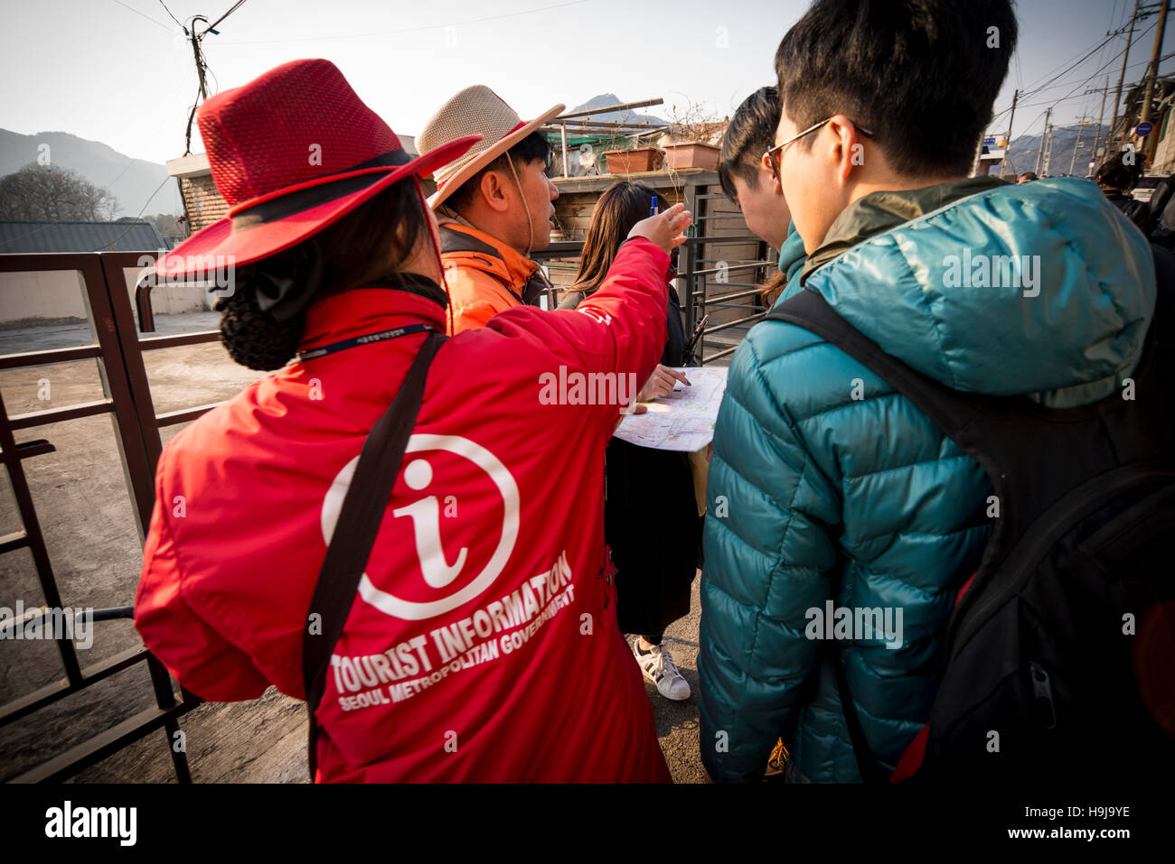 Official Seoul Tourist Information Warden helping tourists in the street, Seoul, Korea Stock Photo