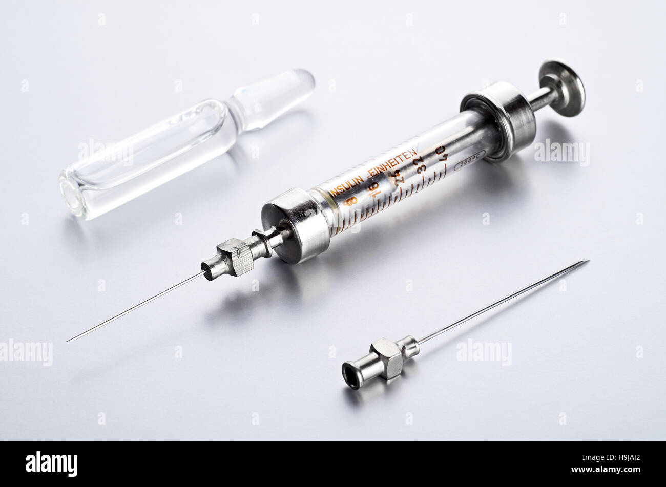 Vintage insulin syringe with insulin vial on a blue background. A
