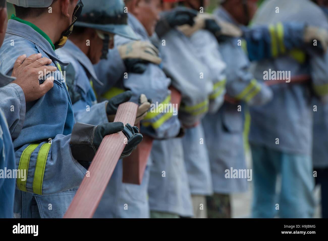 the firefighters hold the fire hose Stock Photo Alamy