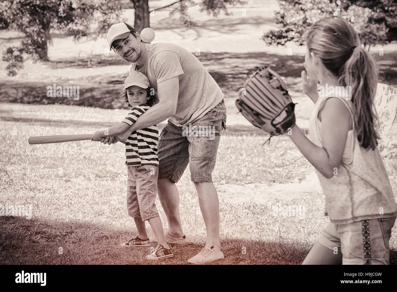 Family playing baseball in the park Stock Photo