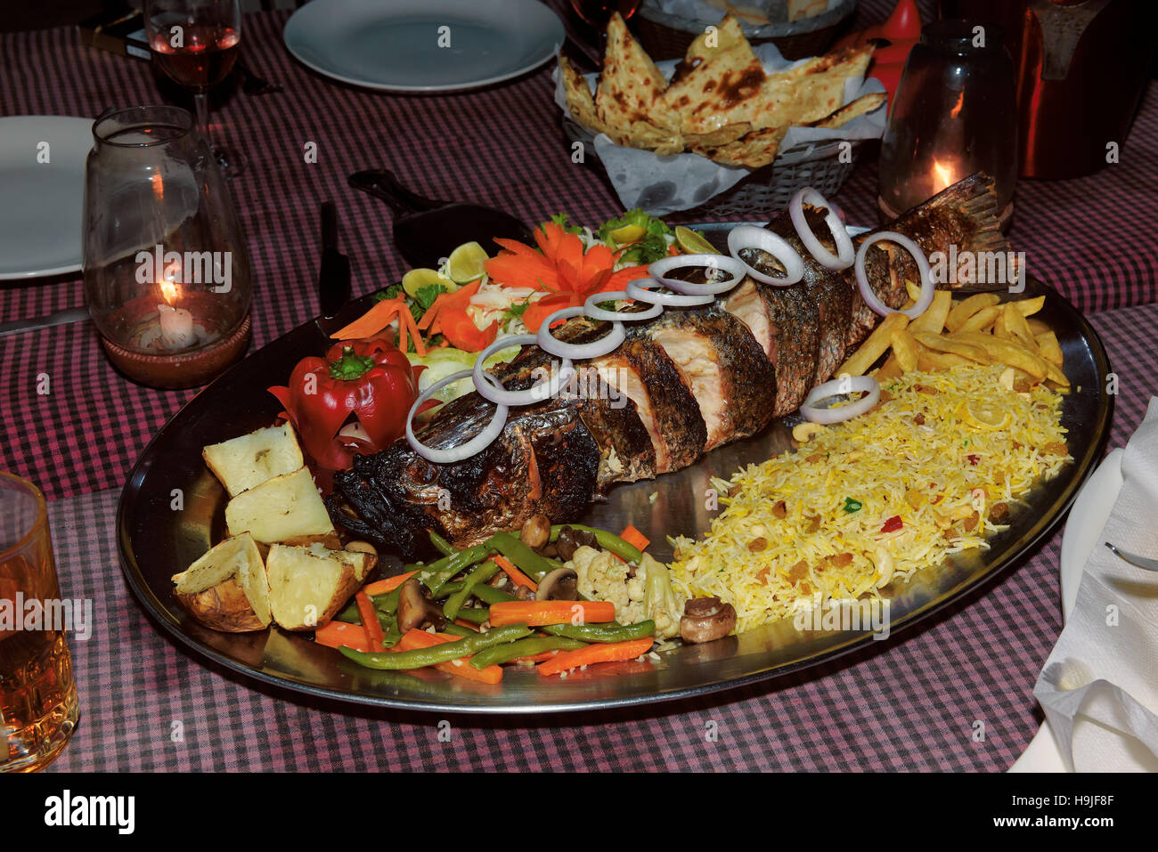 Sea fish cooked on the Tandoori with rice and vegetables. Stock Photo