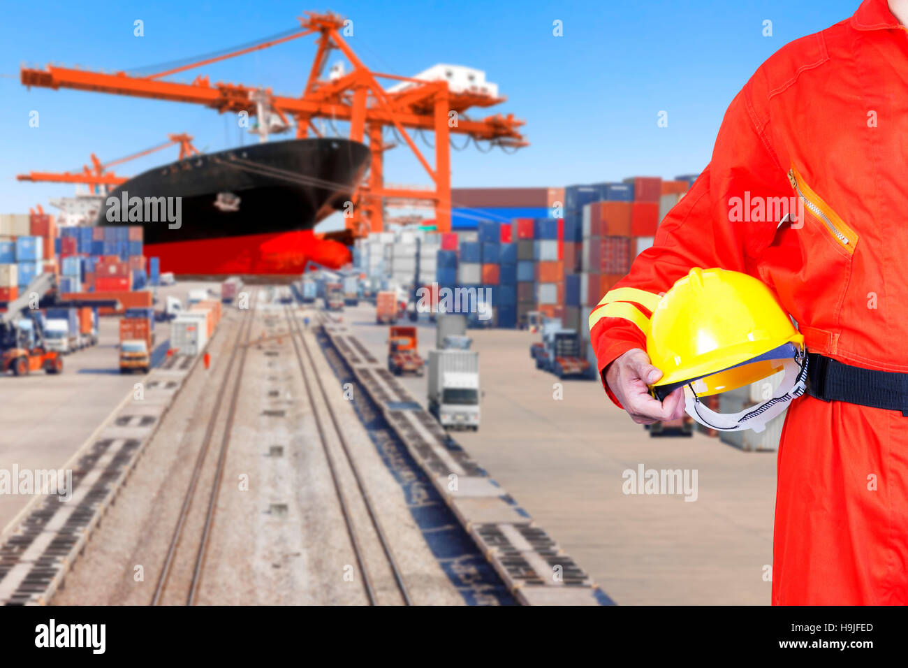Dock worker holding hard hat for controlling work process container