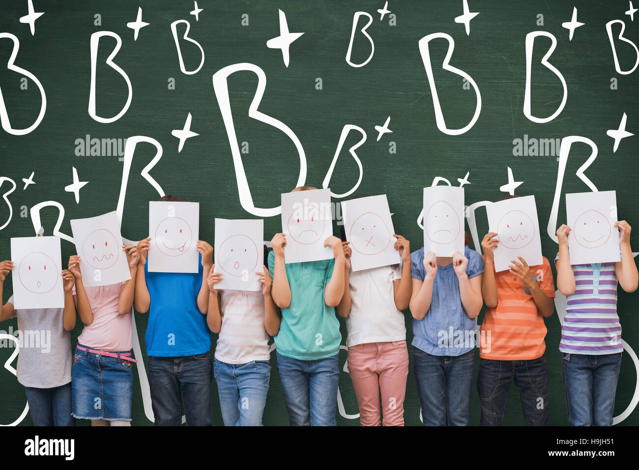 Composite image of cute pupils with funny faces in classroom Stock Photo