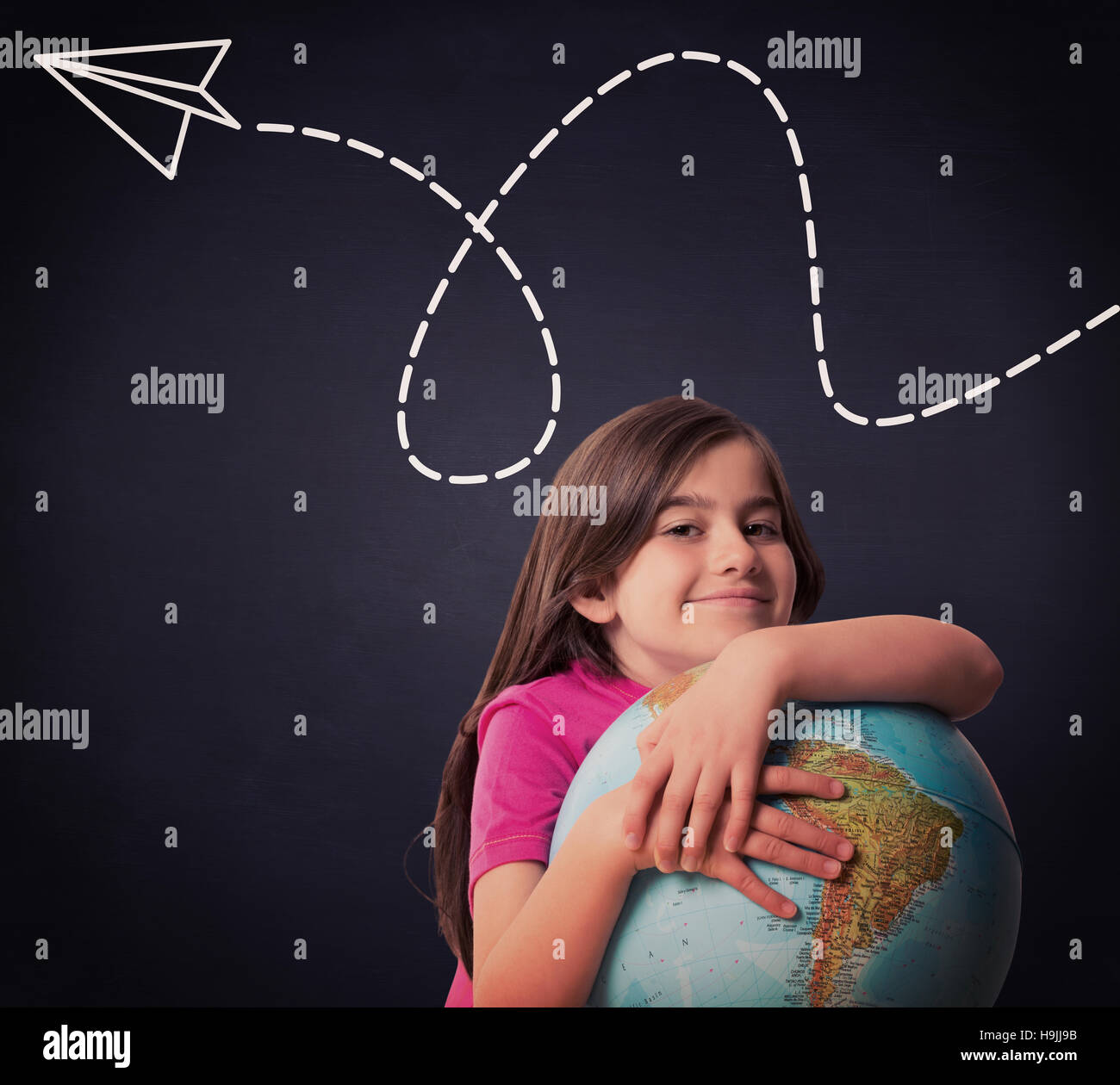 Composite image of cute pupil smiling holding globe Stock Photo - Alamy