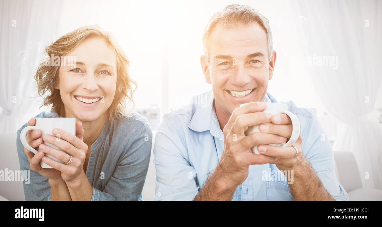 Smiling middle aged couple sitting on the couch having coffee Stock ...