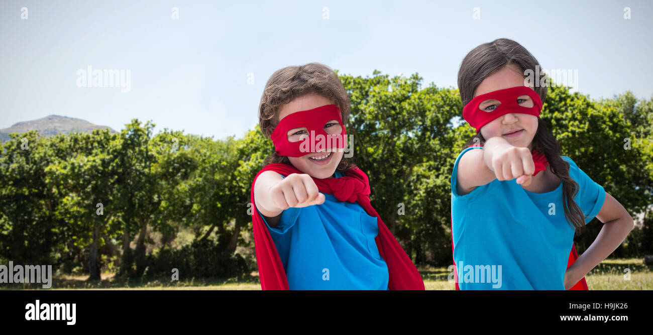 Composite image of portrait of cute siblings with red cap and mask Stock Photo