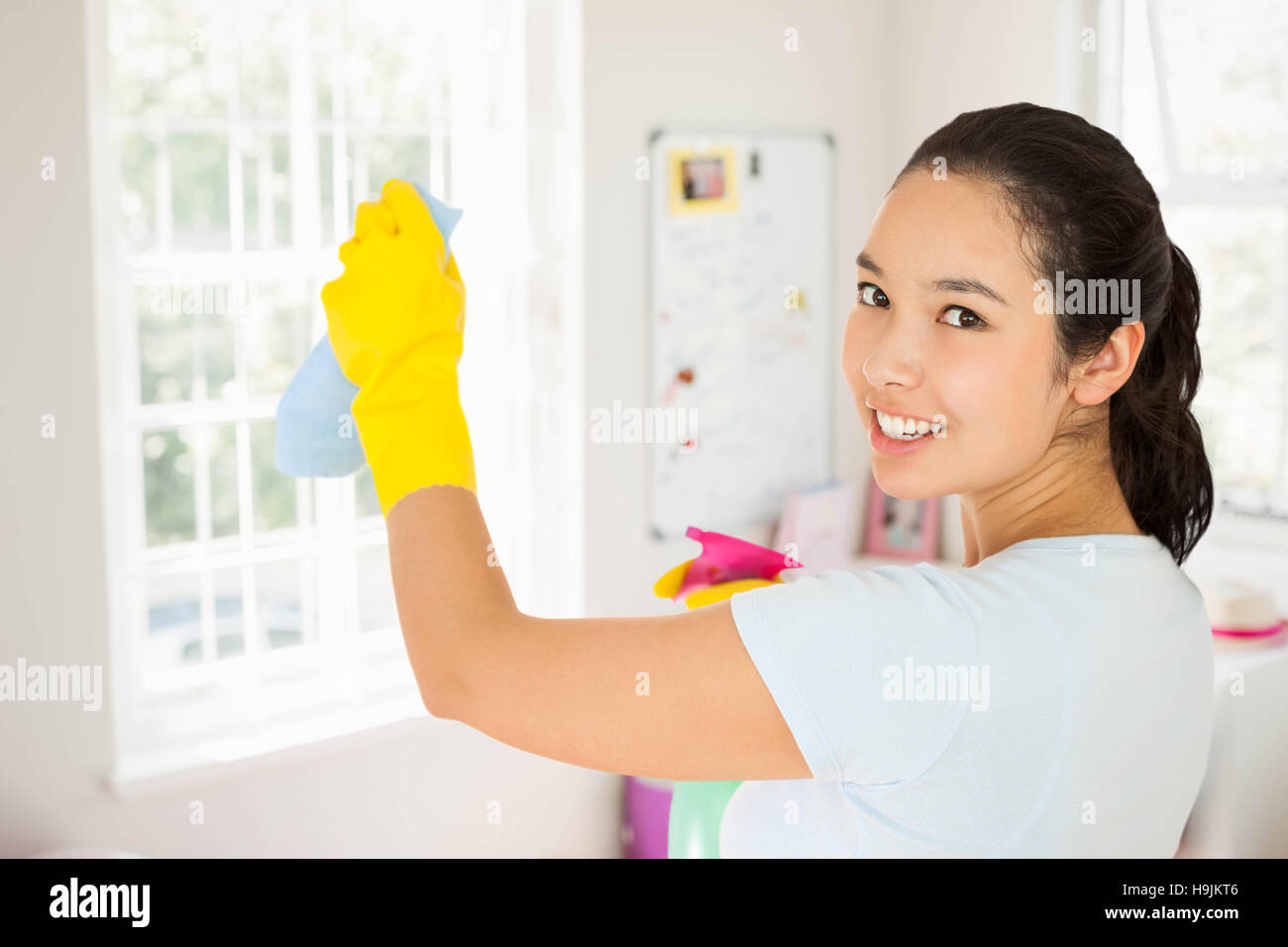 Composite image of smiling woman cleaning walls Stock Photo