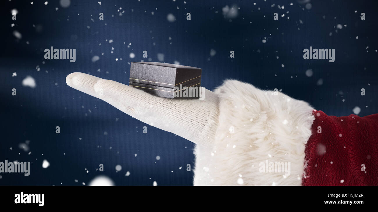 Composite image of santas hand shows a small box Stock Photo
