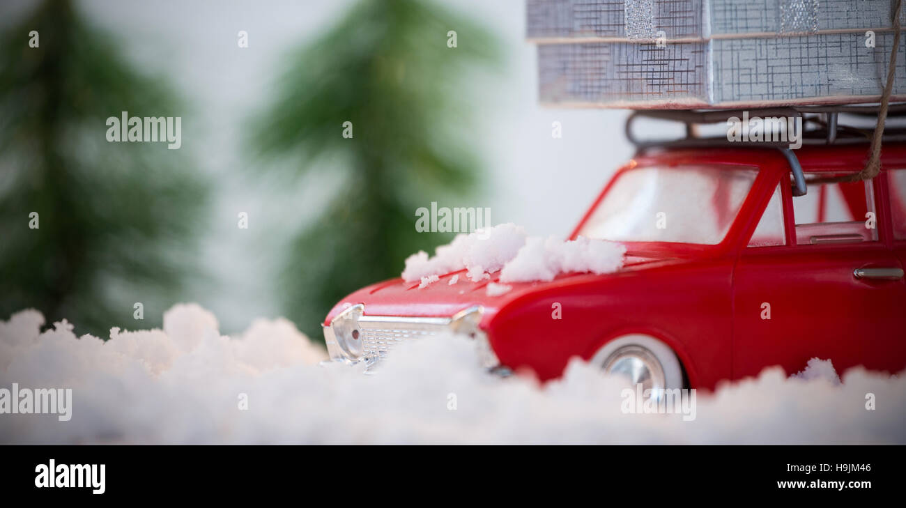 Toy car carrying christmas present on fake snow Stock Photo