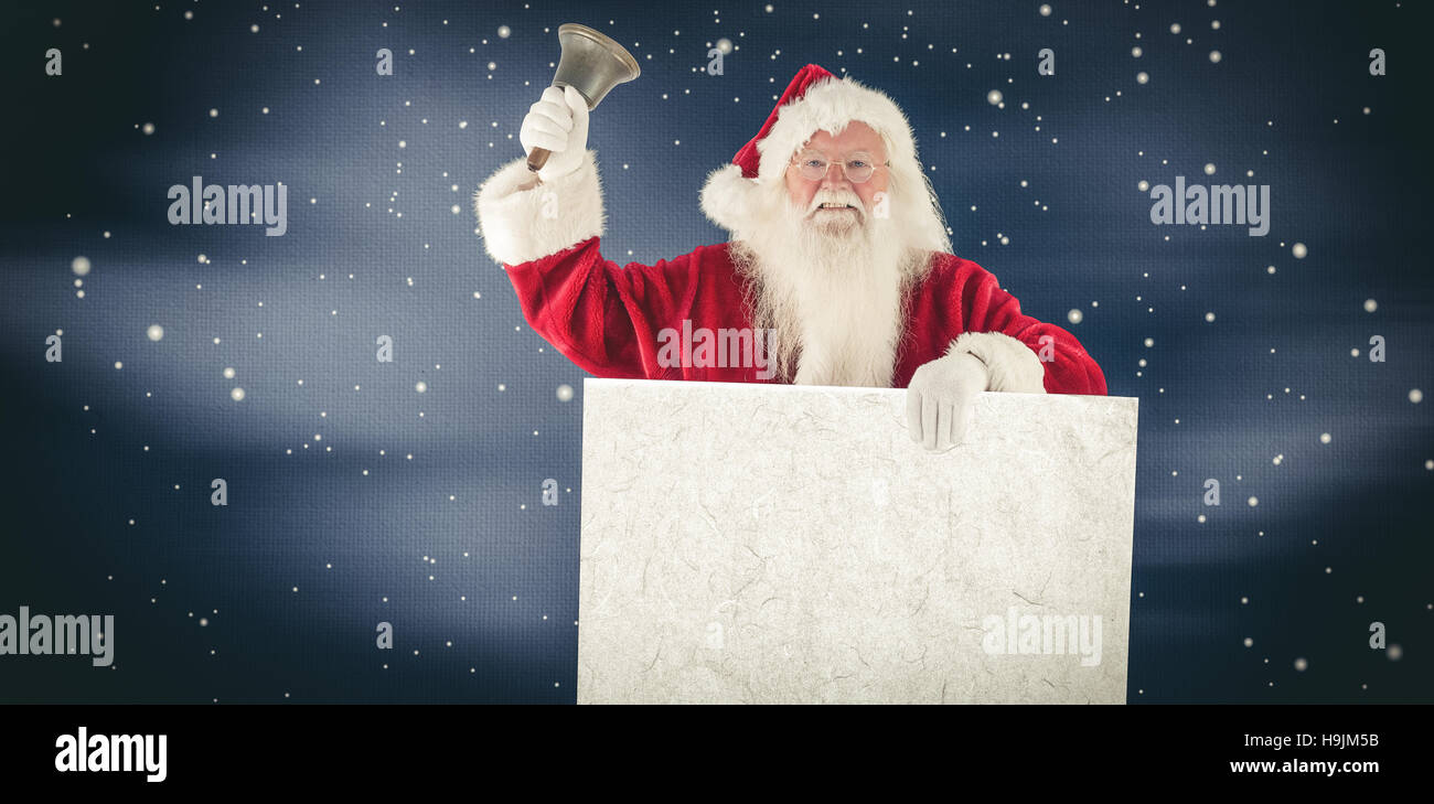 Composite image of santa holds a sign and rings his bell Stock Photo