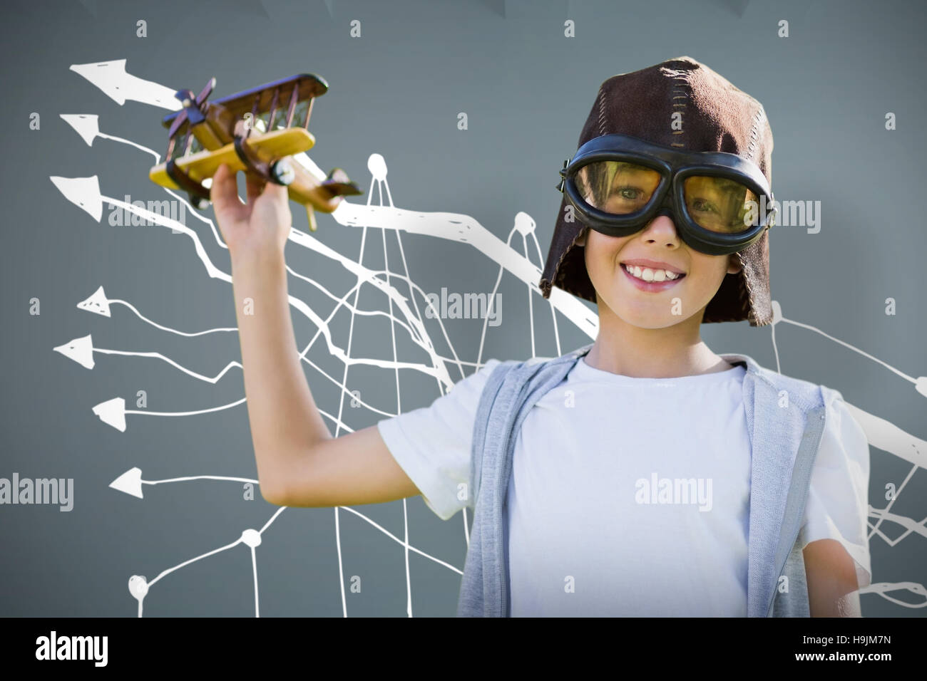Composite image of portrait of boy wearing flying goggles with toy Stock Photo