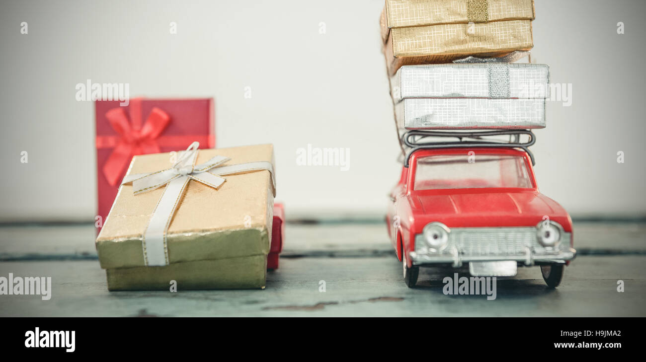 Toy car carrying christmas present on wooden plank Stock Photo