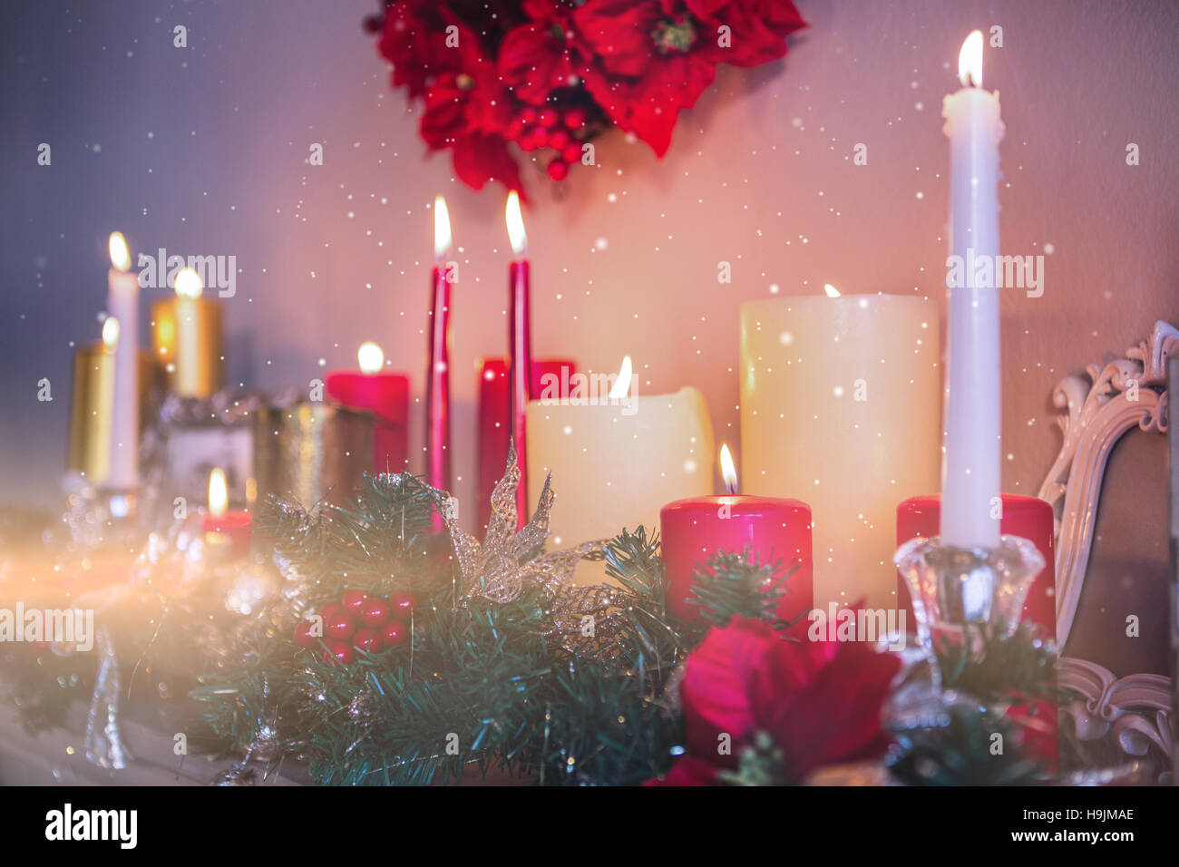 Candles and christmas decorations arranged on fireplace Stock Photo