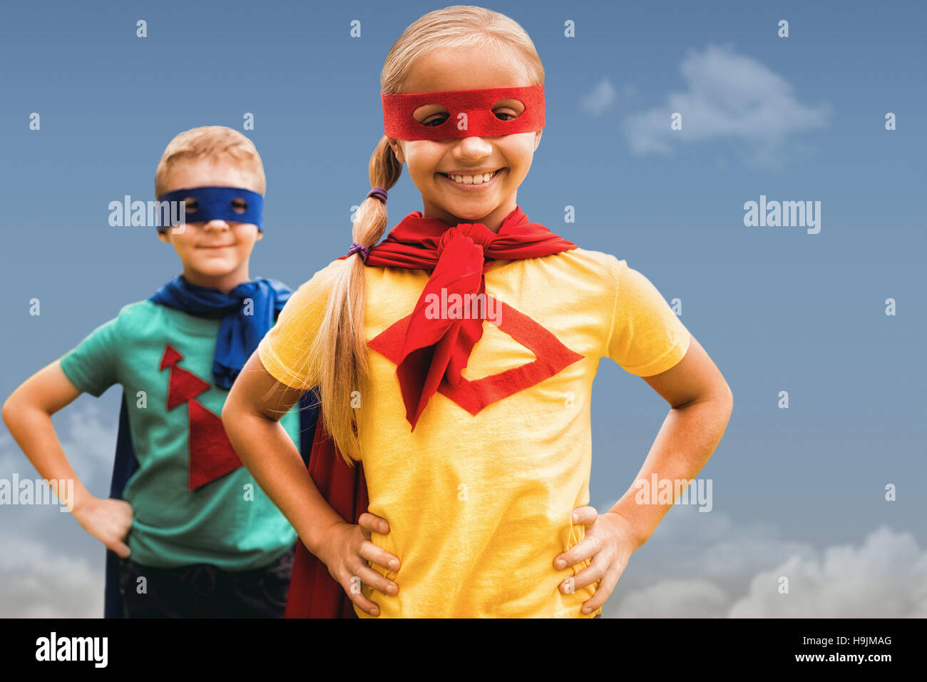 Composite image of siblings with hands on hip Stock Photo