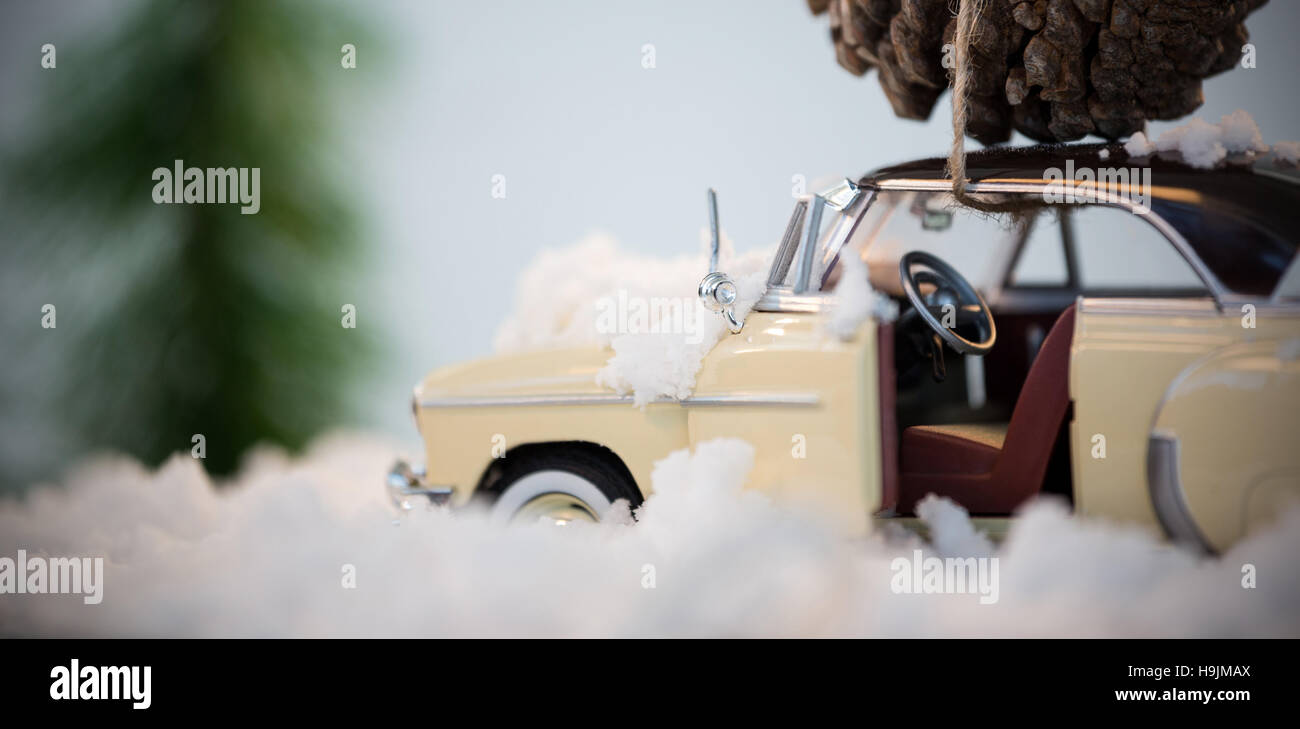 Toy car carrying pine cone on fake snow Stock Photo
