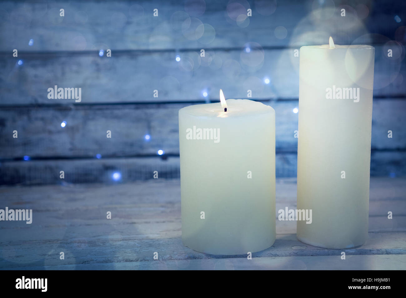 Candles burning on wooden plank Stock Photo