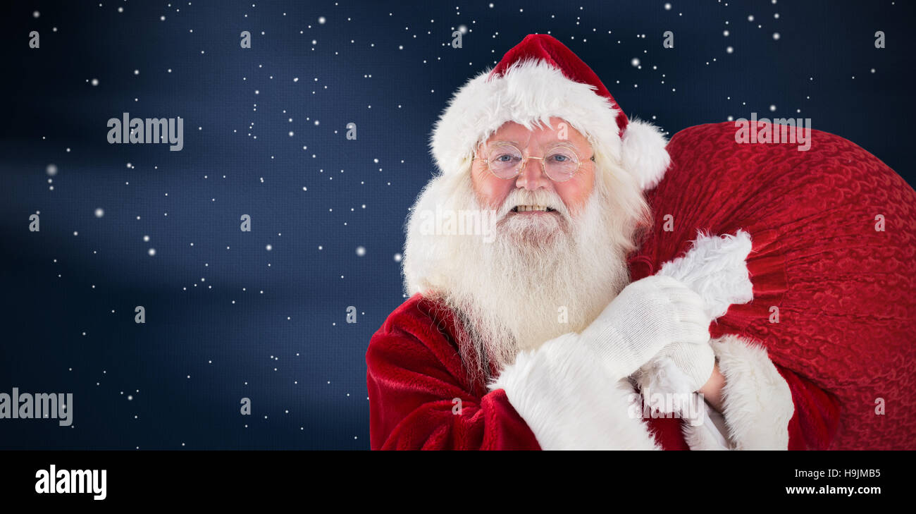 Composite image of jolly santa carries his sack Stock Photo - Alamy