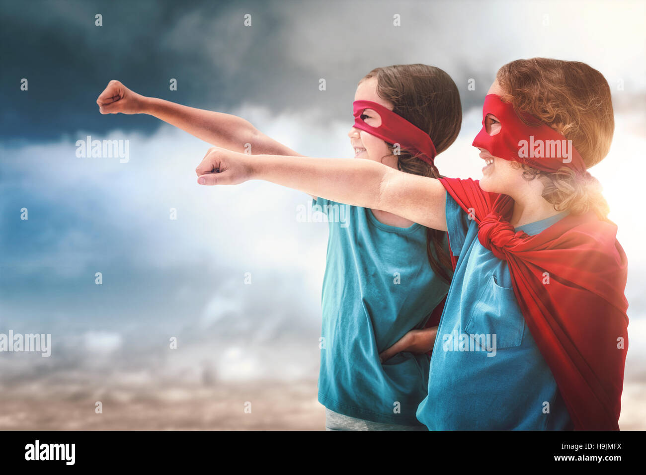 Composite image of sister and brother in red cape Stock Photo