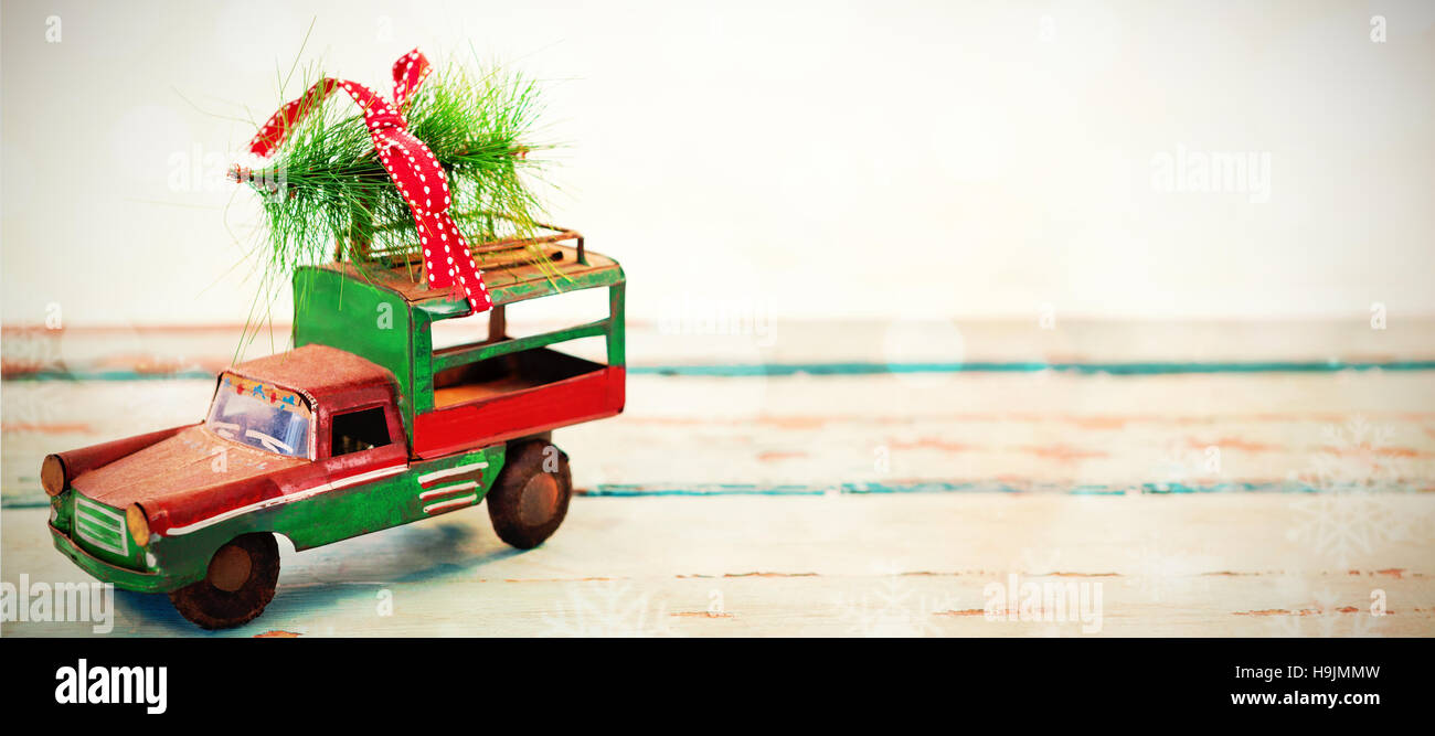 Toy tempo carrying christmas fir on wooden plank Stock Photo