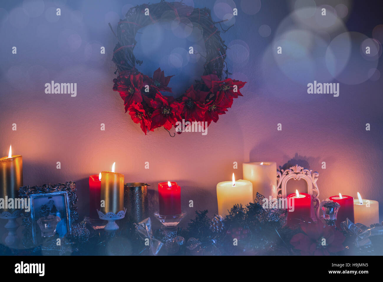 Candles and christmas decorations arranged on fireplace Stock Photo