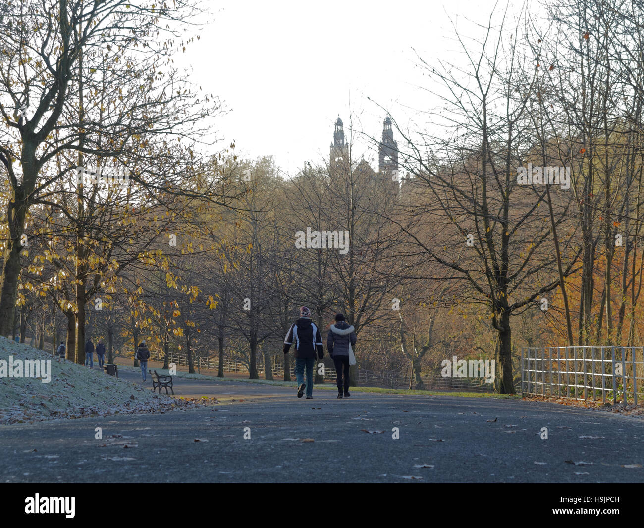 Glasgow park scene couple walking with towers of the museum in the background in kelvingrove park Stock Photo