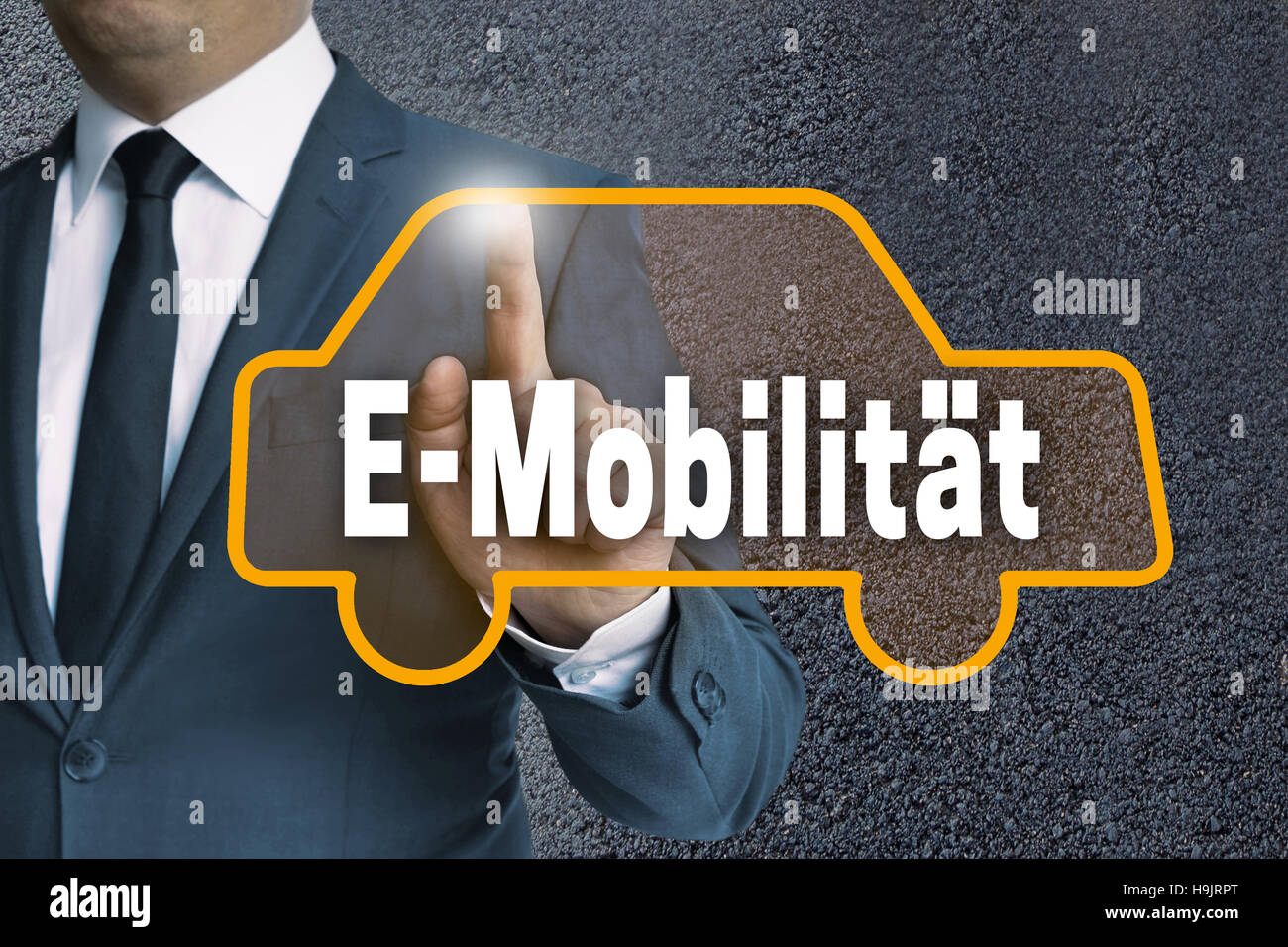 E-Mobilitaet (in german E-mobility) touchscreen is shown by businessman. Stock Photo