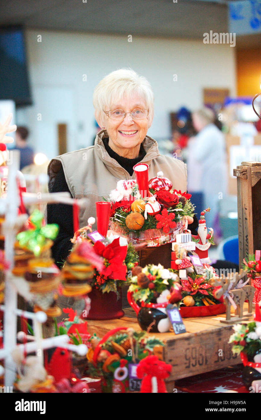 Old women selling her handmade products at a Christmas Market in the city of Norwich Stock Photo