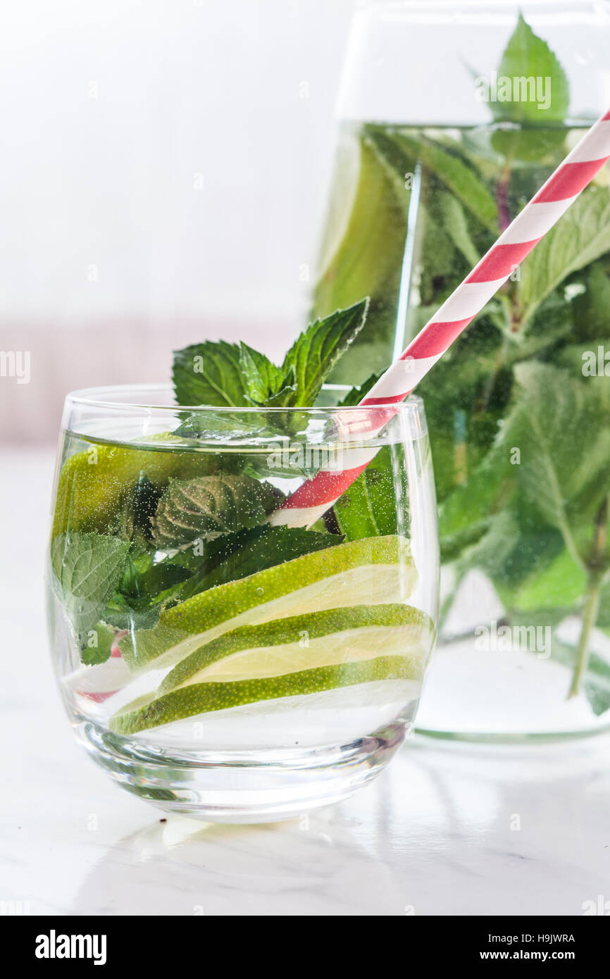 Glass and carafe of detox water with mint and limes Stock Photo