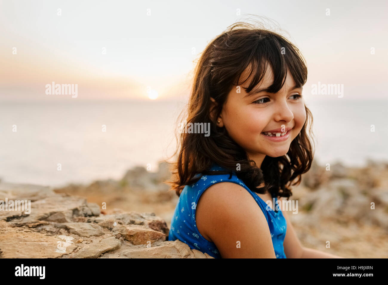 Portrait of happy little girl near the sea at sunset Stock Photo - Alamy