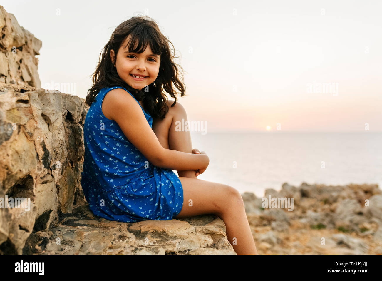Portrait of happy little girl near the sea at sunset Stock Photo - Alamy