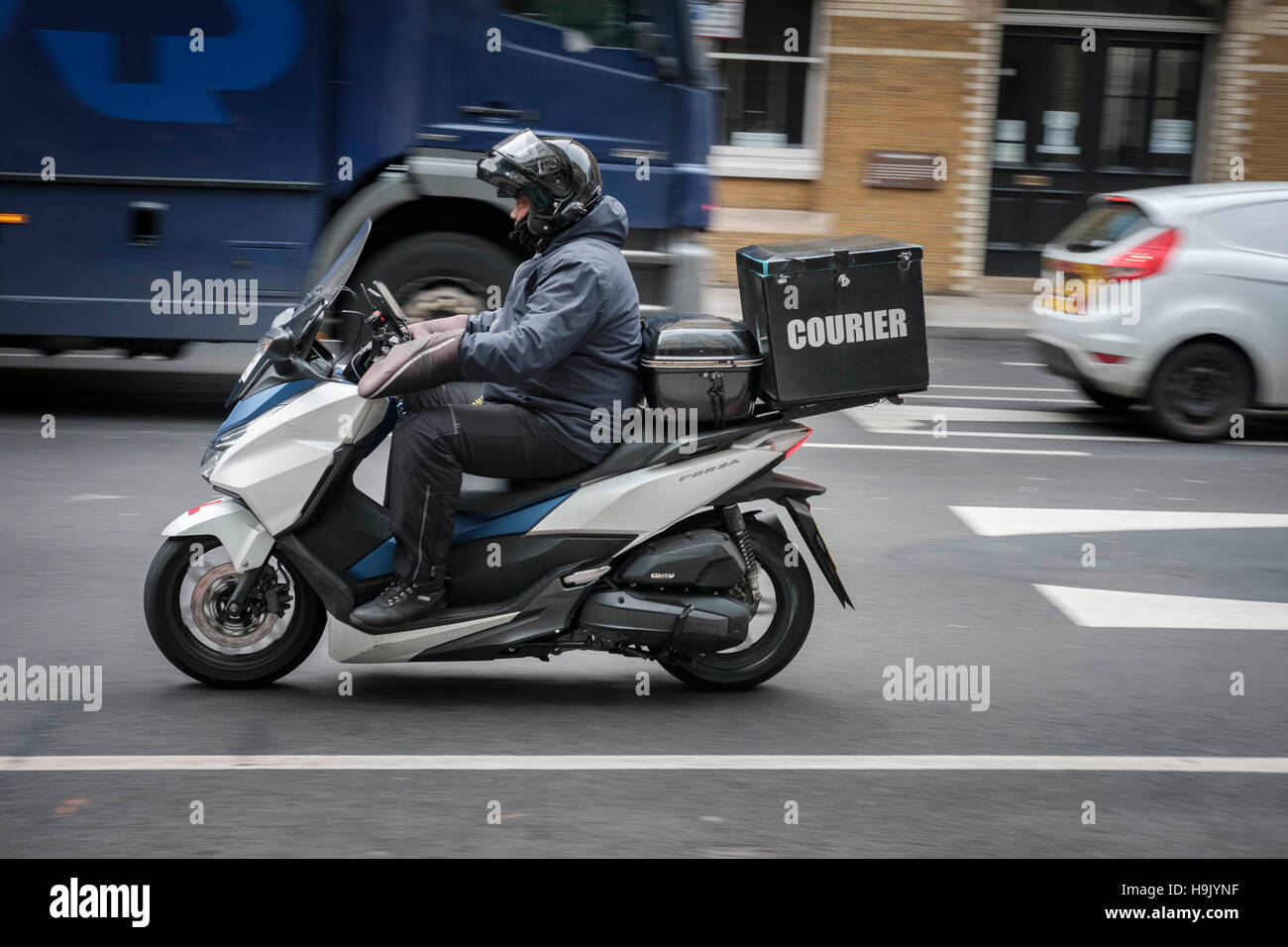 Motorcycle courier speeding on London street,London,England Stock Photo