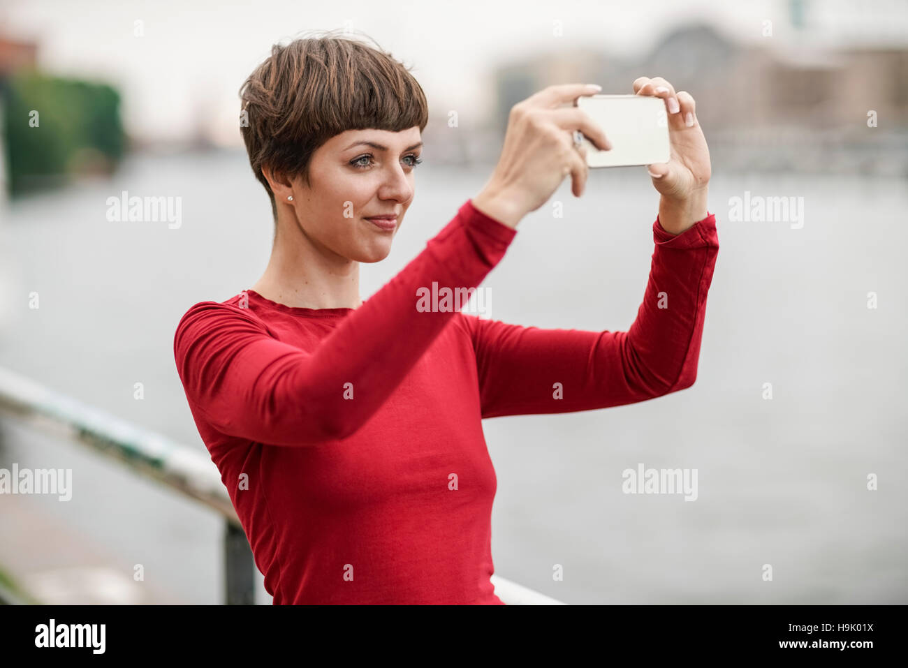 Portrait of young woman taking selfie with smartphone Stock Photo - Alamy