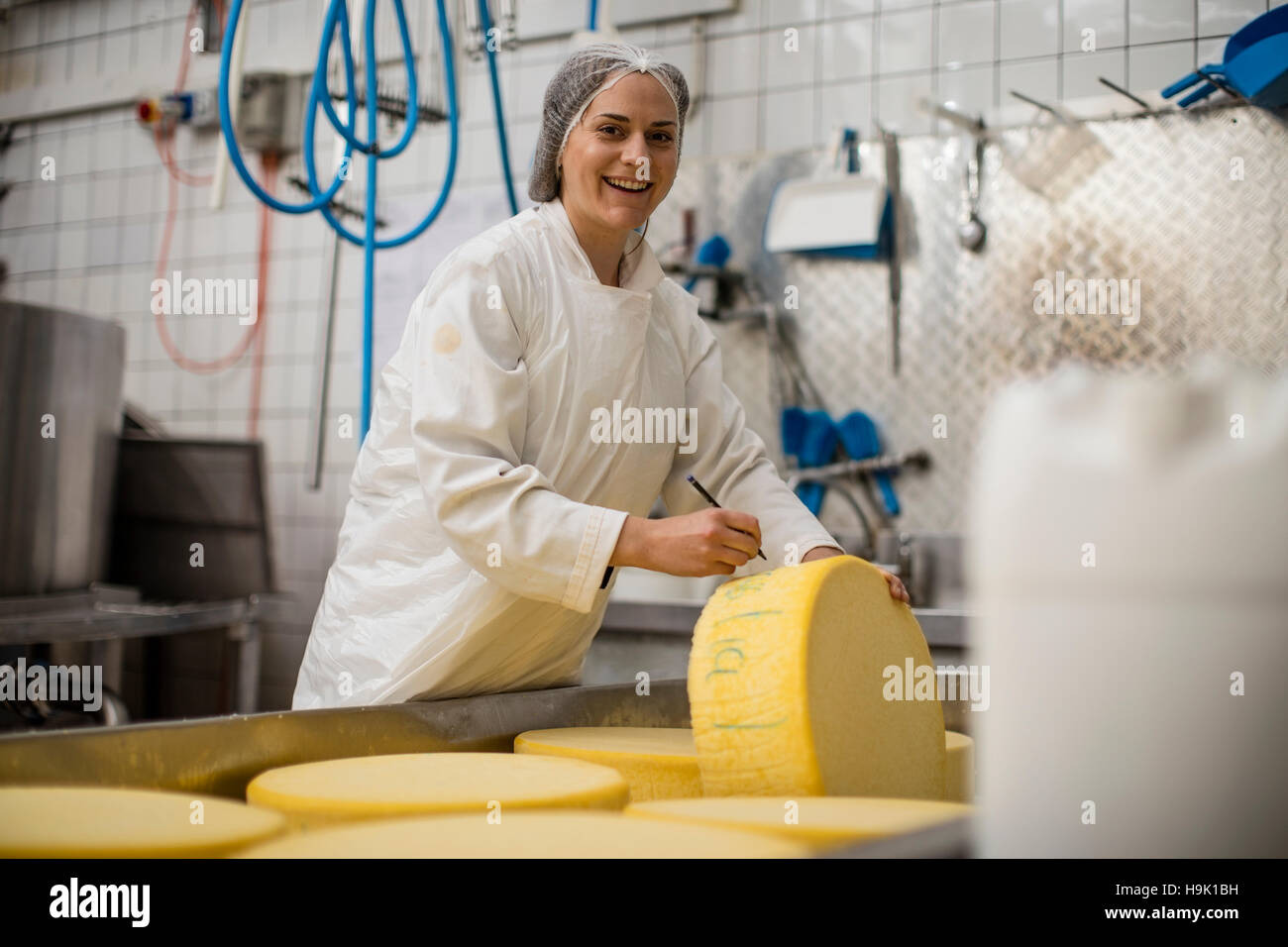 Cheese factory worker labelling cheese wheel Stock Photo Alamy