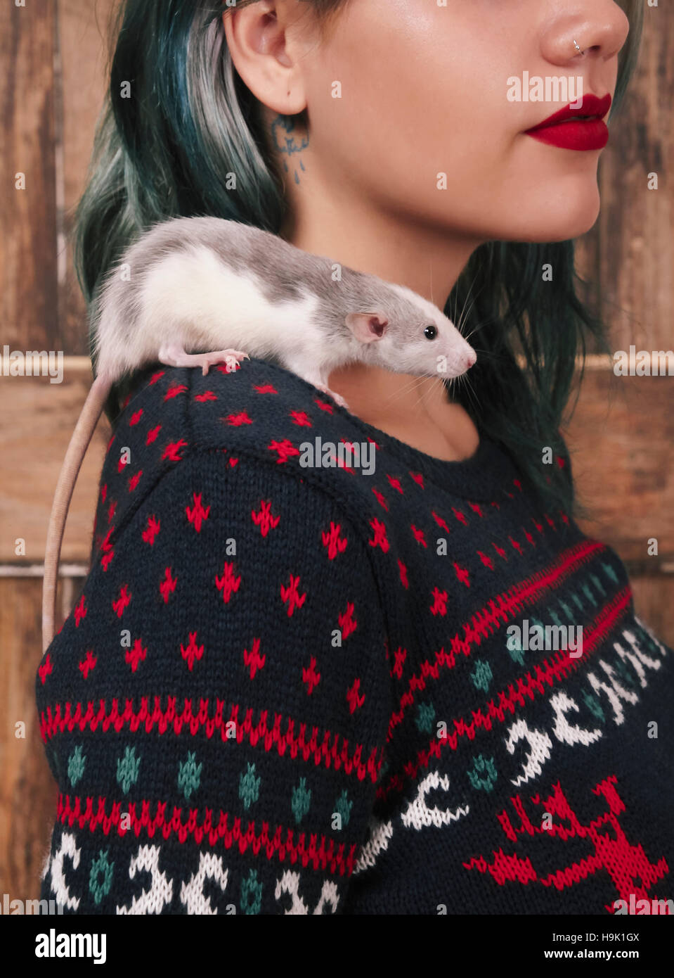 Young woman with pet rat on her shoulder wearing patterned knit pullover Stock Photo