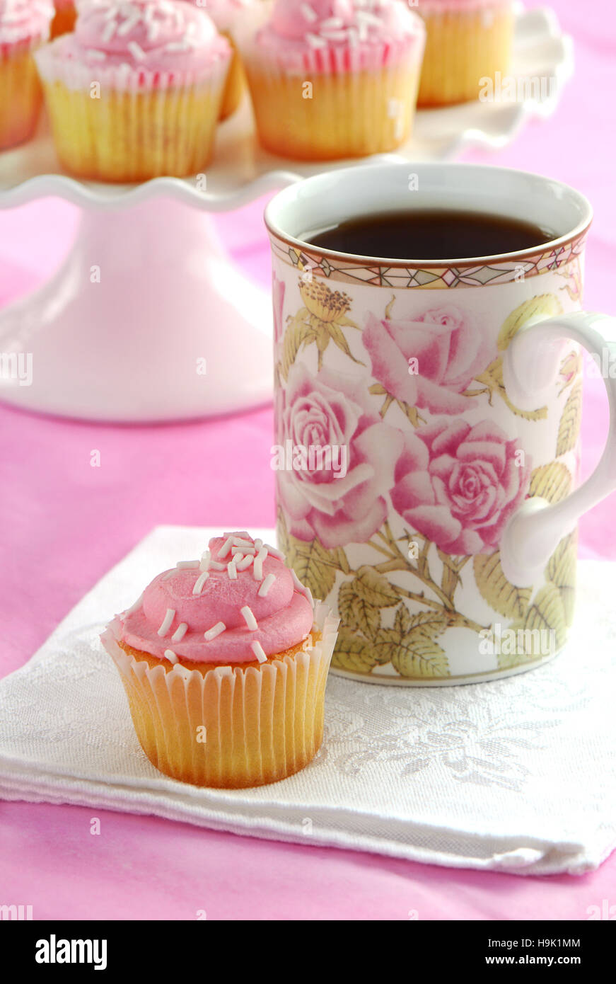 Delicate sweet mini strawberry cupcakes with tea in floral mug in vertical  format. Pedestal cake stand with several cupcakes in background. Shallow  Stock Photo - Alamy