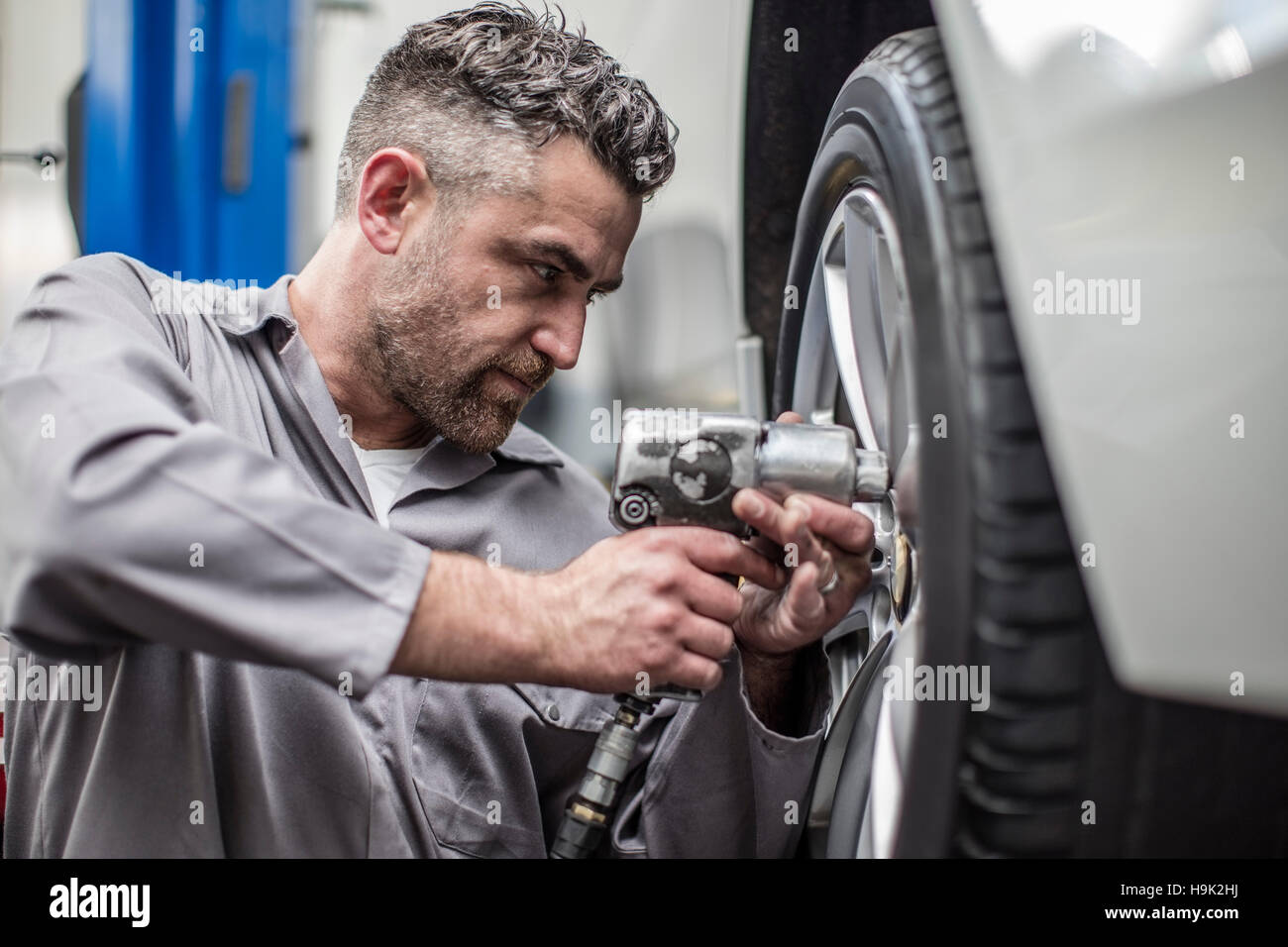 Car mechanic in a changing tire Stock Photo Alamy