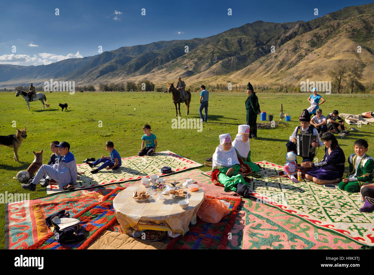 Saty townsfolk gathered for a picnic in pasture by the Chilik river and Kungey Alatau mountains Kazakhstan Stock Photo