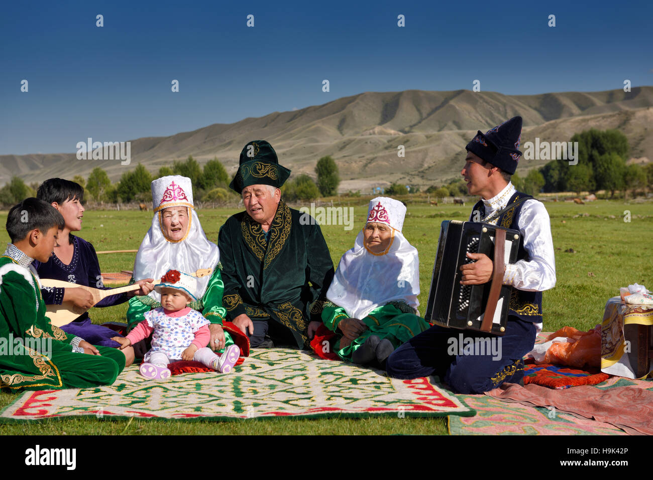 Traditional Kazakh family singing at a picnic in pastureland of Saty Kazakhstan Stock Photo