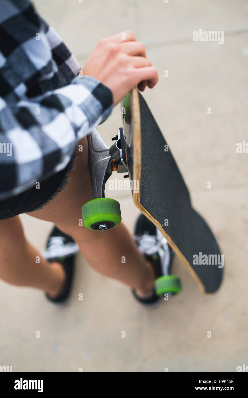 Woman with skateboard, partial view Stock Photo