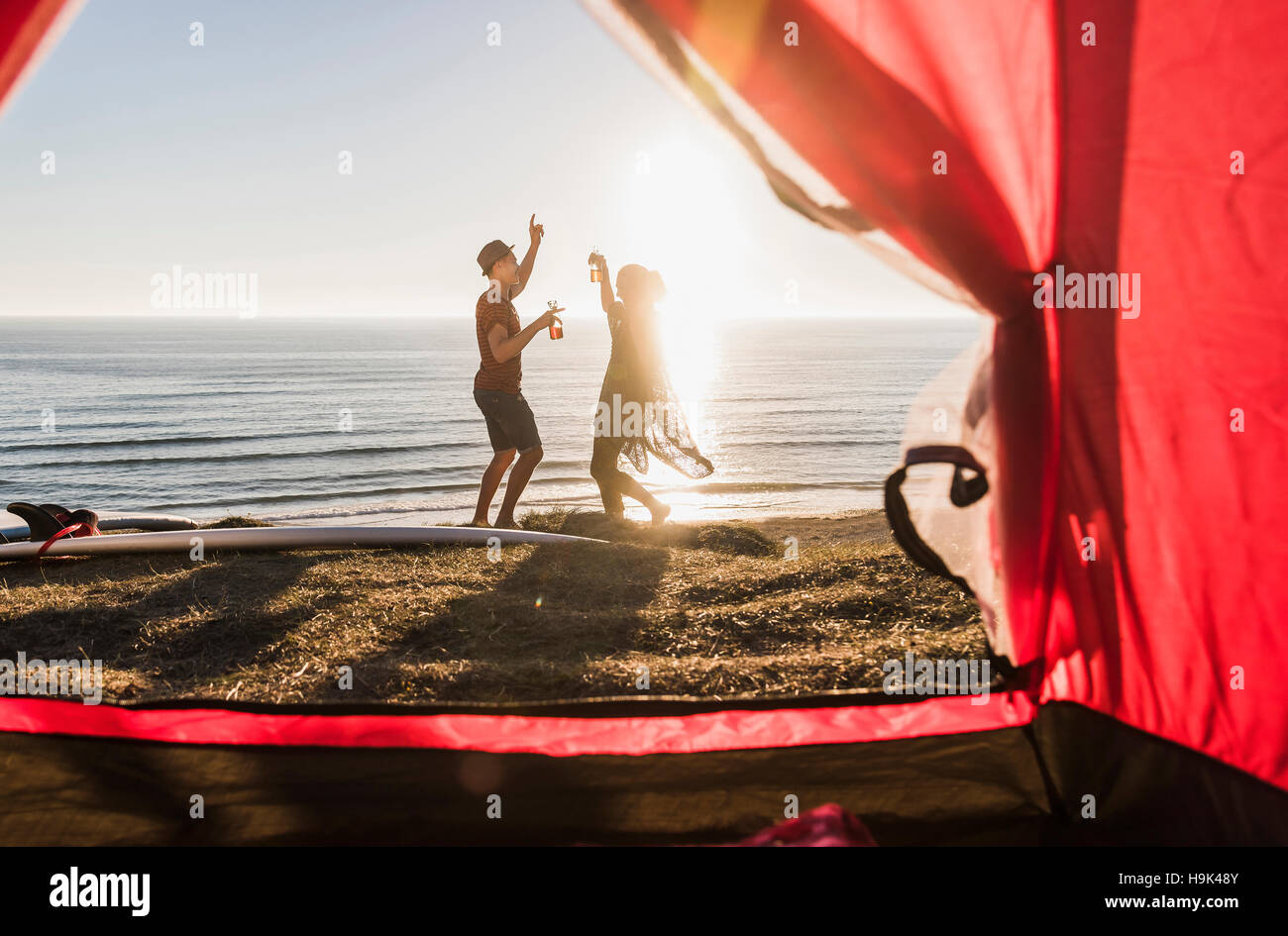 Dancing young couple camping at seaside Stock Photo
